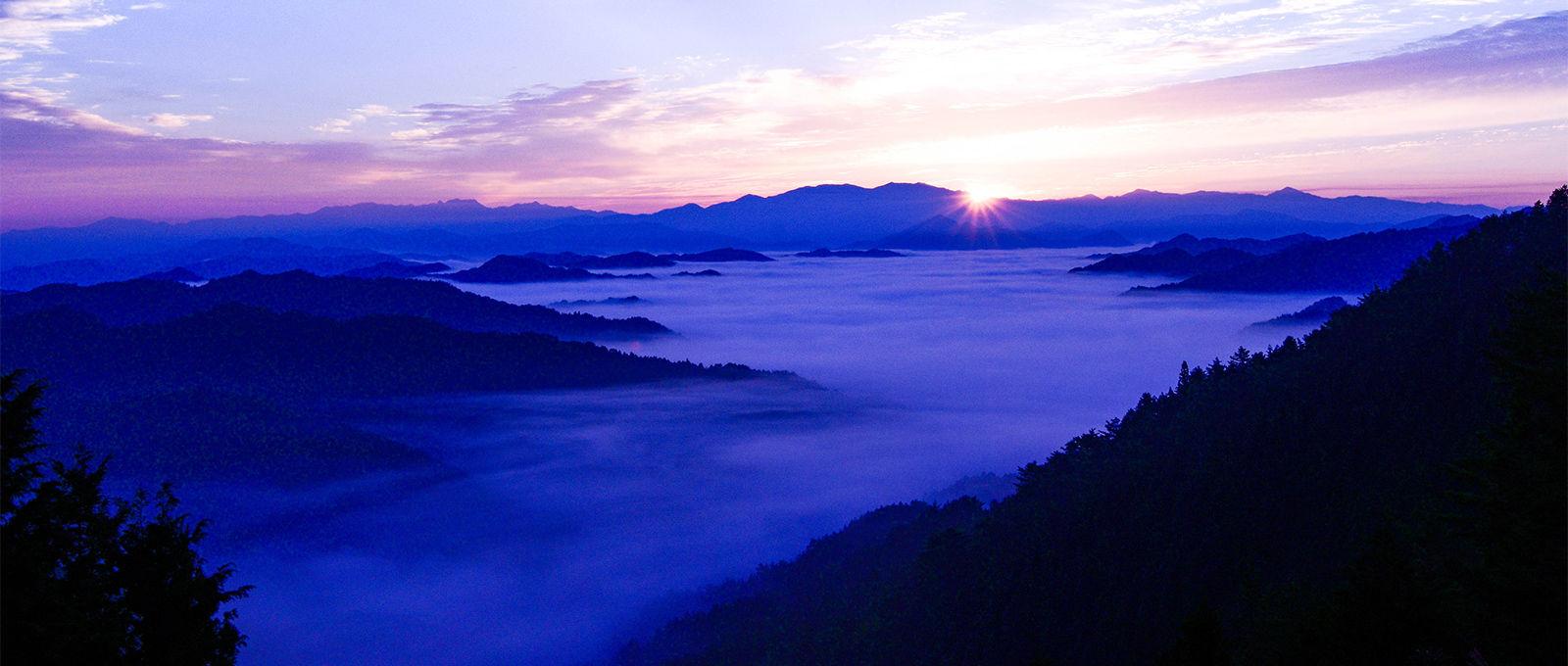 山から朝日が昇る写真