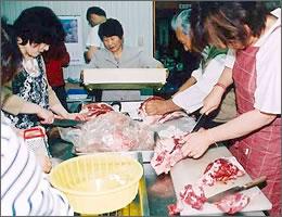 骨のついた肉を切っている写真