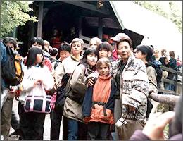 建物の前で記念撮影をする現地の学生と中学生の写真