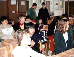 教室のようなところで話を聞く現地の学生と中学生の写真