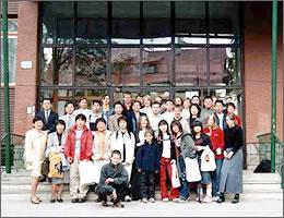 建物の前で集合写真を撮る現地の学生と中学生の写真