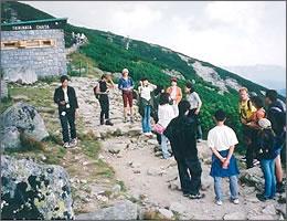 開けた山道の道中で説明を聞く一行の写真