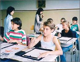 習字で「平和」と書こうとする現地の学生たちと先生の写真