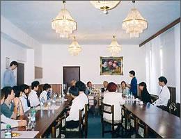 絵画やシャンデリアのある部屋で話を聞く中学生たちの写真