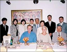夕食会のテーブルを前に記念撮影をしている写真