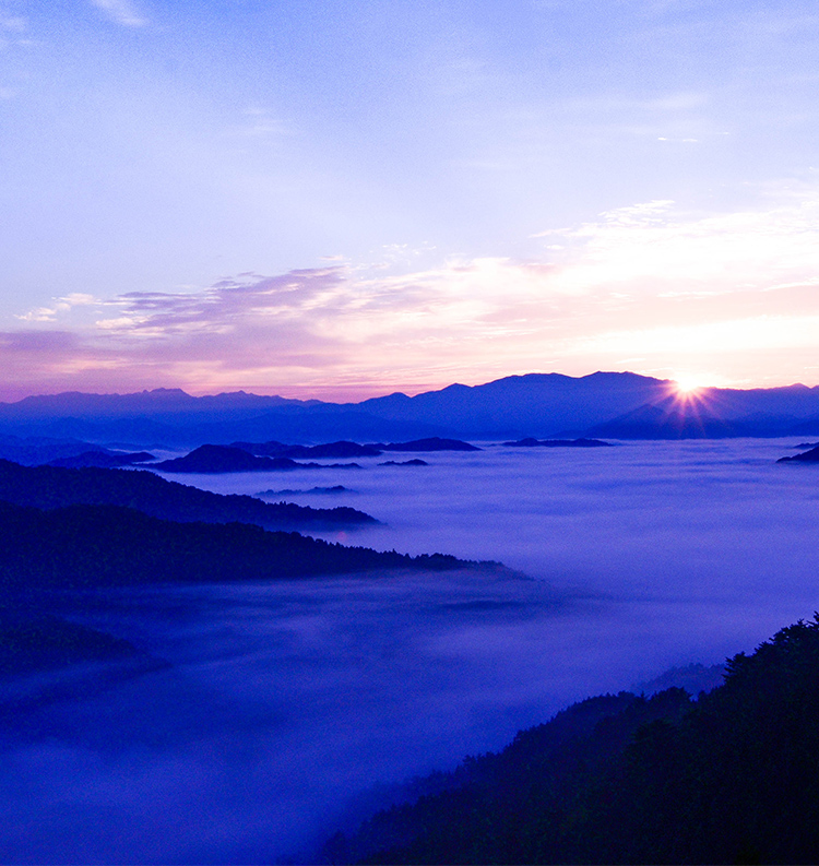 山から朝日が昇っている写真