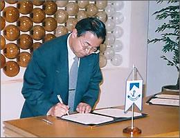 副島日本大使は協定書に署名する時の写真