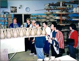 工場内で焼く前のツボが並ぶ棚を見学する訪問団の写真